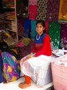 A girl, a teenager - a seller of fabrics in a street shop