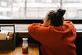 Girl teenager sitting in a cafe at a table waiting and looking out the window Royalty Free Stock Photo