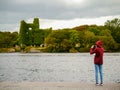 Girl teenager taking picture on her smart phone of Menlo castle, Ireland, Galway, Concept: tourist, adventure, technology