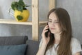 Girl teenager talking on phone sitting on couch in living room. Telephone call Royalty Free Stock Photo