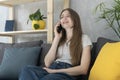 Girl teenager talking on phone sitting on  couch in living room. Telephone call Royalty Free Stock Photo