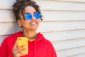 Girl teenager teen female young African American woman wearing sunglasses using cell phone Royalty Free Stock Photo