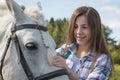 Girl teenager and white horse in a park in a summer Royalty Free Stock Photo