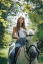 Girl teenager and white horse in a park in a summer Royalty Free Stock Photo