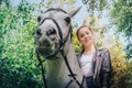 Girl teenager and white horse in a park in a summer Royalty Free Stock Photo