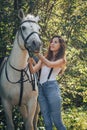 Girl teenager and white horse in a park in a summer Royalty Free Stock Photo