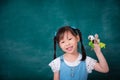 Girl telling a story by finger puppet in front of chalkboard Royalty Free Stock Photo