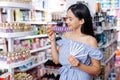 Girl with testers in perfumery, choosing perfume in cosmetic shop