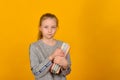 Girl with textbooks in hand stands on a yellow background Royalty Free Stock Photo