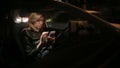 Girl texting on smart phone in car at night