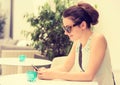 Girl texting on the smart phone in a hotel restaurant terrace Royalty Free Stock Photo