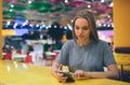 Girl texting on the smart phone in a restaurant terrace with an unfocused background. Royalty Free Stock Photo