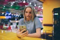 Girl texting on the smart phone in a restaurant terrace with an unfocused background Royalty Free Stock Photo