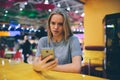 Girl texting on the smart phone in a restaurant terrace with an unfocused background Royalty Free Stock Photo