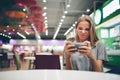 Girl texting on the smart phone in a restaurant terrace with an unfocused background Royalty Free Stock Photo