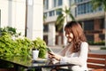 Girl texting on the smart phone in a restaurant terrace with an unfocused background Royalty Free Stock Photo