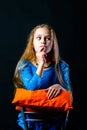 Girl thinks sitting on a chair on a black background