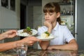 The girl thoughtfully chooses a dish for lunch