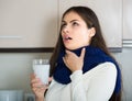 Girl with throat pain gargling throat in kitchen