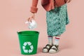 Girl is throwing crumpled paper in recycling bin. Royalty Free Stock Photo