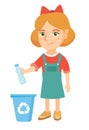 Girl throwing plastic bottle in recycle bin.