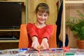 A girl throws large dice making another move while playing a board game at the table