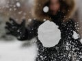 The girl throws a snowball at the camera. The snowball shatters into snowflakes