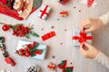 The girl ties the bow on the gift. Desk with gifts and decorations. Royalty Free Stock Photo