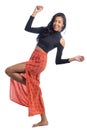 Girl tilts her body back and throws her knee forward. Afrodescendant woman wearing orange skirt..