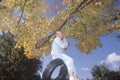 A girl on a tire swing in autumn,