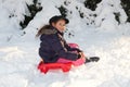 Girl with toboggan in the snow