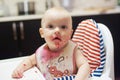 Playing with food and learning to eat concept. Dirty face of happy kid. Portrait of a baby eating with a stained face. Royalty Free Stock Photo