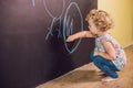 Girl toddler paint with chalk on a blackboard Royalty Free Stock Photo