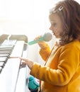 Girl toddler plays with piano and toy microphone Royalty Free Stock Photo