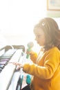 Girl toddler plays with piano and toy microphone Royalty Free Stock Photo