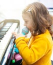 Girl toddler plays with piano and toy microphone Royalty Free Stock Photo