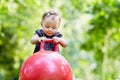 Girl toddler plays with red ball for jumping on Royalty Free Stock Photo