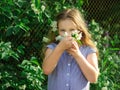 Girl toddler sniffing flowers in a cup. Jasmine tea flower blossomed in a cup Royalty Free Stock Photo