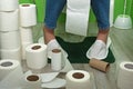 Girl in the toilet among the rolls of paper. Stomach problems