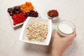 The girl took milk to pour it into oatmeal. Useful and healthy breakfast. White background Royalty Free Stock Photo