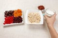 The girl took milk to pour it into oatmeal. Useful and healthy breakfast. White background Royalty Free Stock Photo