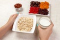 The girl took milk to pour it into oatmeal. Useful and healthy breakfast. White background Royalty Free Stock Photo