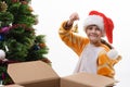 The girl took out a toy bell out of the box and is going to hang it on the Christmas tree Royalty Free Stock Photo