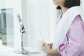 Girl with toothbrush and mug brushing teeth at mirror in restroom Royalty Free Stock Photo