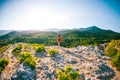 Girl at the top of the mountain. A woman with a backpack is standing on a rock. Climb to the top. Travel to picturesque places. Royalty Free Stock Photo