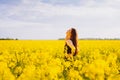 Girl touches her neck on rapeseed meadow Royalty Free Stock Photo