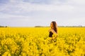Girl touches her shoulder on rapeseed meadow Royalty Free Stock Photo