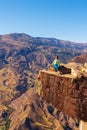 Girl tourist on an extreme ledge in the rock Troll tongue