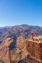 Girl tourist on an extreme ledge in the rock Troll tongue