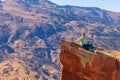 Girl tourist on an extreme ledge in the rock Troll tongue